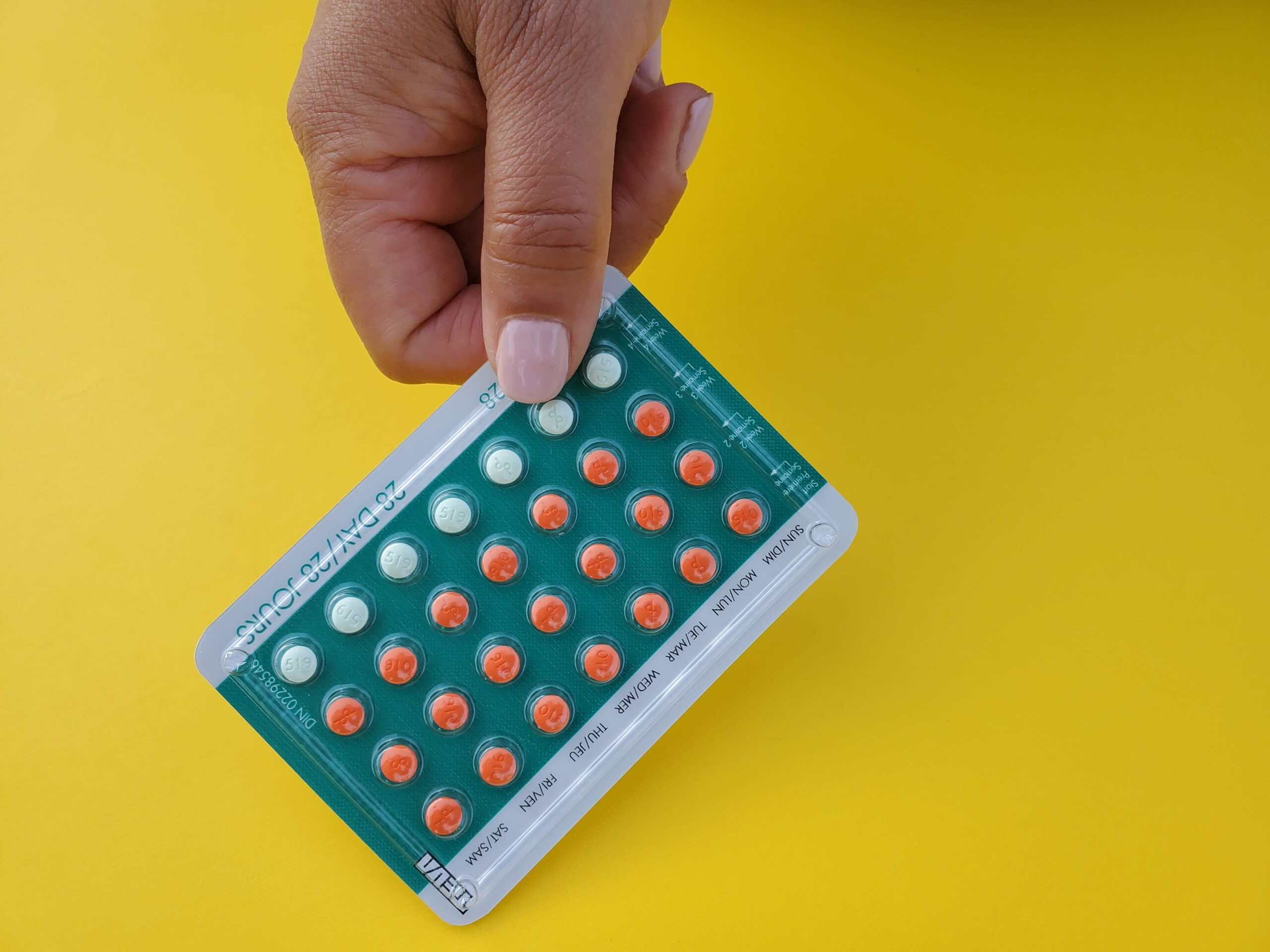 A person holding a packet of birth control